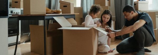 Your address and your auto insurance: Parents and a child surrounded by moving boxes in their home