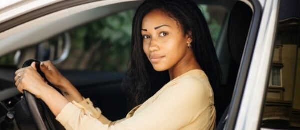 Young woman in driver seat thinking about driving test fees in Ontario